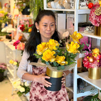 Mellow Yellow 6 yellow glitter roses in a black and gold hatbox
