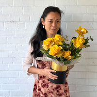 Mellow Yellow 6 yellow glitter roses in a black and gold hatbox